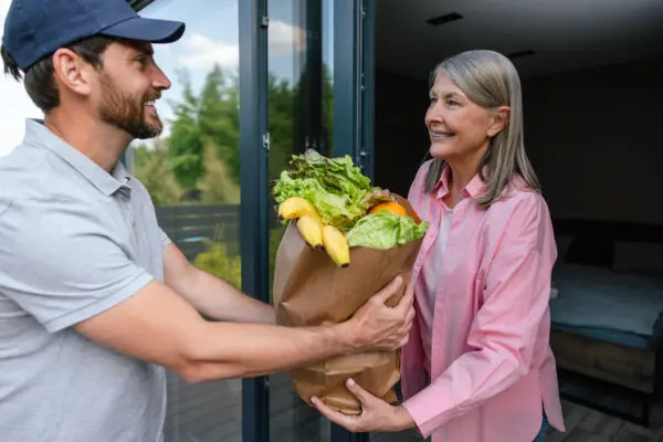 A man handing a woman some food in a bag