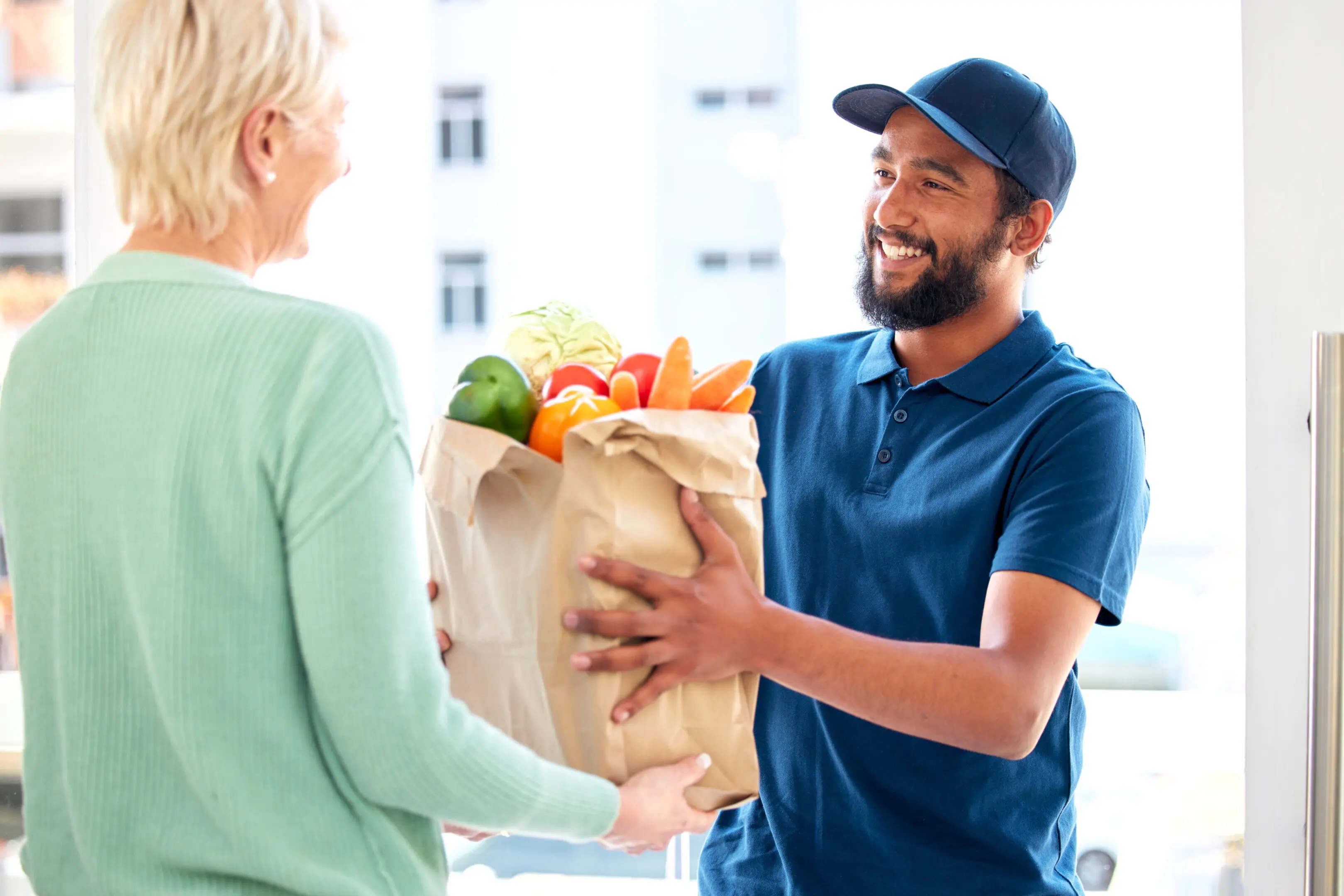 A man handing a woman some food in a bag