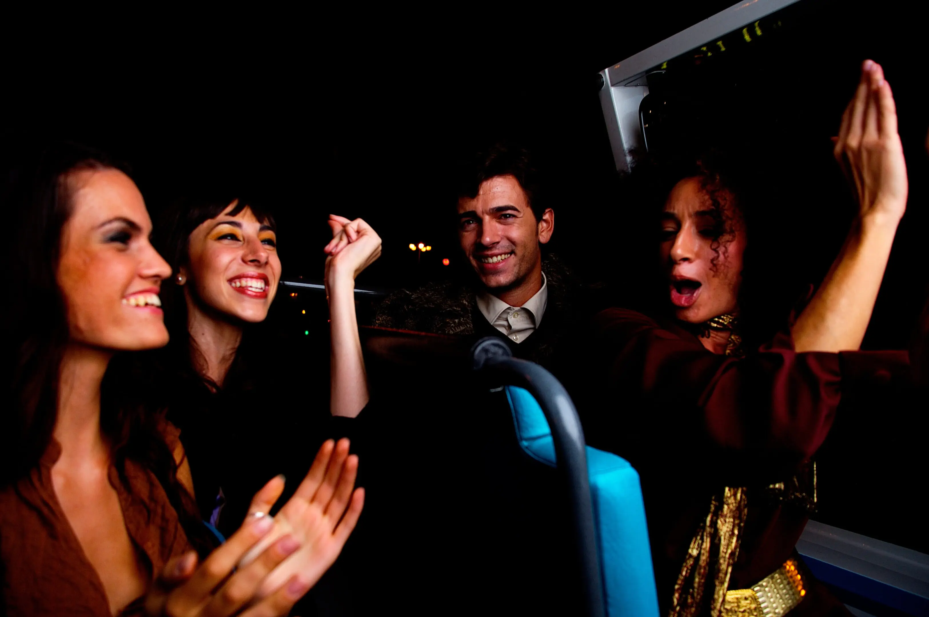 A group of people on a bus with one man holding something up to his ear.